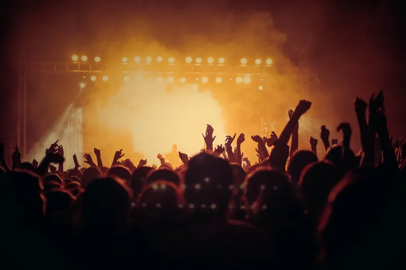 Escenario de concierto con luces y público.